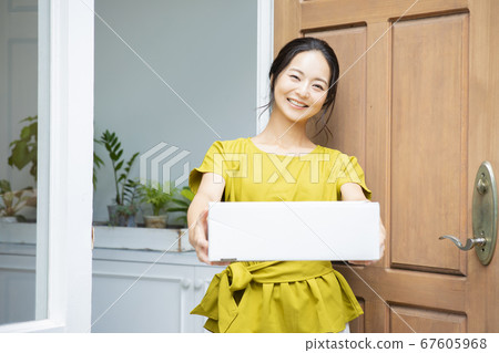 Smiling woman with cardboard box 67605968