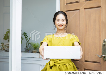 Smiling woman with cardboard box 67605969