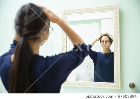 Woman looking in the mirror Woman looking in the mirror 67605994