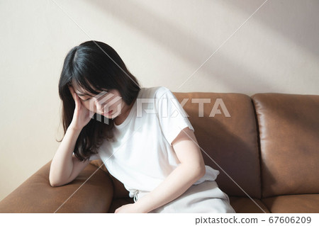 Depressed young asian woman sitting on couch at home. Stressed female thinking about life problems solving feel unhappy, confused and tired. Mental health problem and psychology concept. Copy space. 67606209