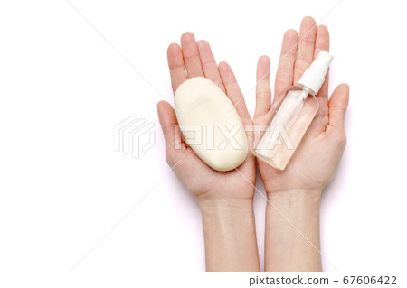 Female hands holding soap and hand sanitizer spray dispenser isolated on white background with clipping path 67606422