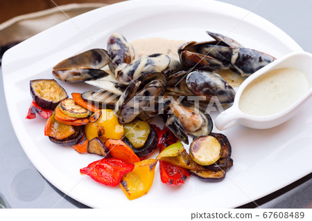 Delicious freshly cooked fresh mussels with sauce. Delicious freshly cooked fresh mussels with sauce. 67608489