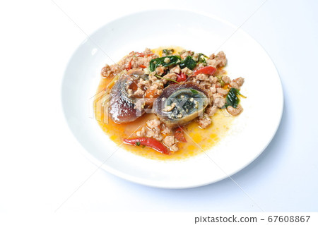 slice boiled  black preserved egg dressing spicy fried chop pork and basil leaf on plate 67608867