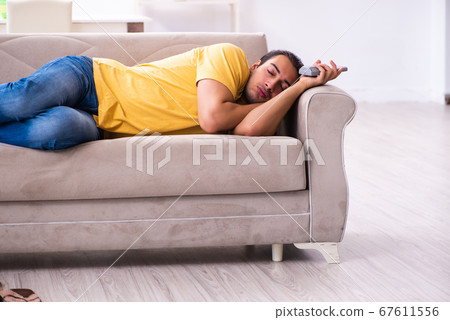 Young man watching tv at home Young man watching tv at home 67611556
