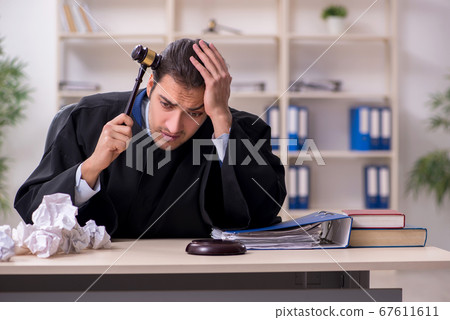 Young male judge working in courthouse Young male judge working in courthouse 67611611
