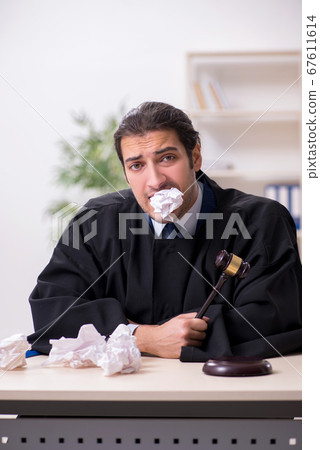 Young male judge working in courthouse 67611614