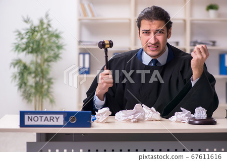 Young male judge working in courthouse Young male judge working in courthouse 67611616