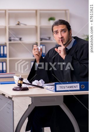Young male judge working in courthouse Young male judge working in courthouse 67611621