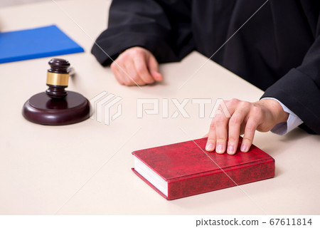 Young male judge working in courthouse 67611814