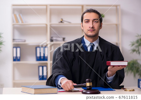 Young male judge working in courthouse 67611815