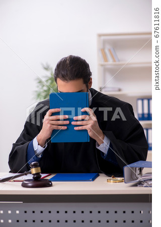 Young male judge working in courthouse 67611816