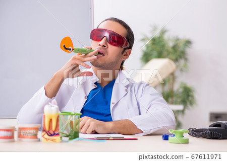 Young male dentist working in the clinic Young male dentist working in the clinic 67611971