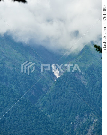 High green mountains with snow in the gorges. High green mountains with snow in the gorges. 67612092