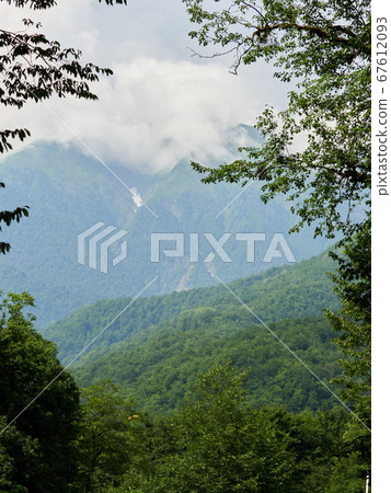 High green mountains with snow in the gorges. 67612093
