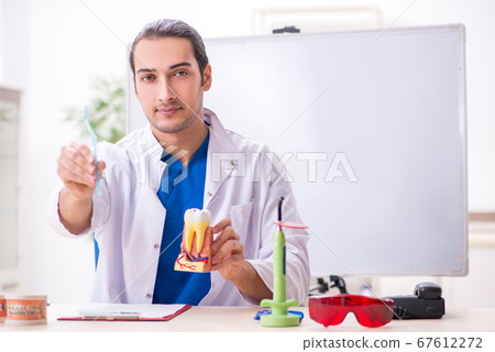 Young male dentist working in the clinic 67612272