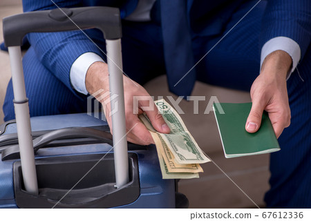 Young businessman holding passport preparing for trip 67612336