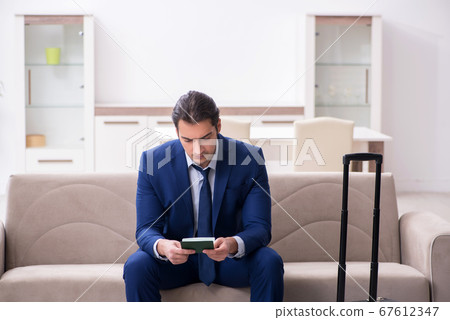 Young businessman holding passport preparing for trip Young businessman holding passport preparing for trip 67612347