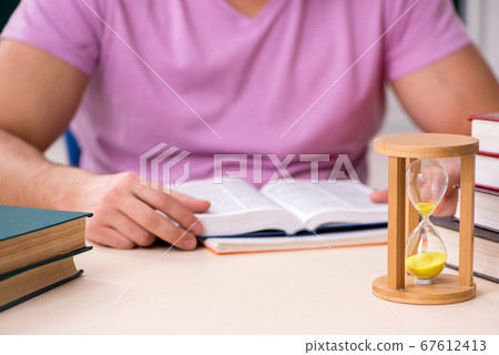 Young male student in the classroom at time management concept Young male student in the classroom at time management concept 67612413