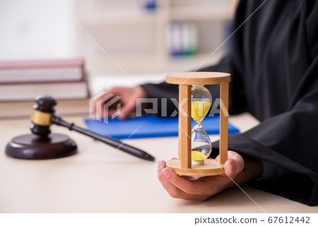 Young male judge in time management concept Young male judge in time management concept 67612442