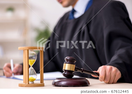 Young male judge in time management concept Young male judge in time management concept 67612445