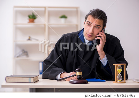 Young male judge in time management concept Young male judge in time management concept 67612462