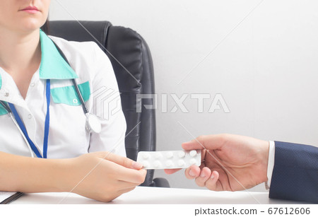 The doctor hands over a package of pills to a patient with psychosis and nervous breakdown. Concept of placebo effect, pills for vegetative dystonia and depression. Copy space for text 67612606