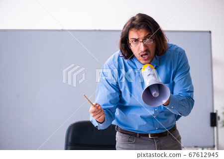 Young male teacher in the classroom Young male teacher in the classroom 67612945