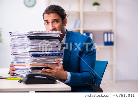 Young male employee unhappy with excessive work Young male employee unhappy with excessive work 67613011