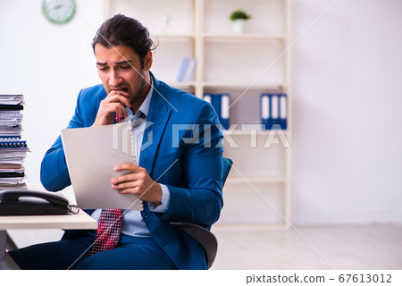 Young male employee unhappy with excessive work Young male employee unhappy with excessive work 67613012