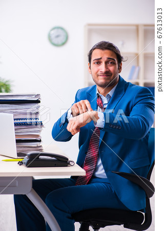 Young male employee unhappy with excessive work Young male employee unhappy with excessive work 67613013