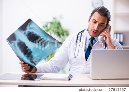 Young male handsome doctor working in the clinic Young male handsome doctor working in the clinic 67613267