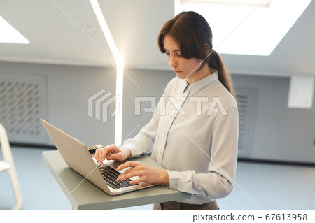Young Woman Working at Standing Table 67613958