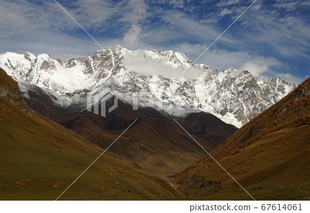 Breathtaking view of snowy mountain peaks around Ushguli village and brown valley at autumn time. Svaneti, Georgia 67614061