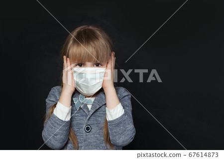Unhappy child girl in medical protective face mask 67614873