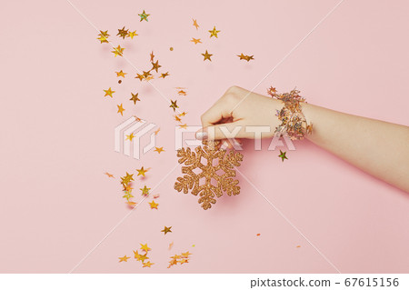 Gold snowflake in female hand and golden stars 67615156