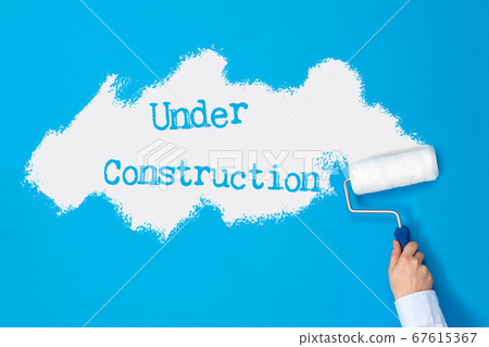 Hand with paint roller paints blue wall Hand with paint roller paints blue wall 67615367
