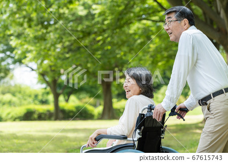 在輪椅上公園散步的年長夫婦 67615743