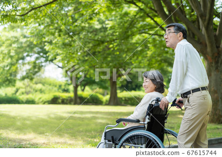 在輪椅上公園散步的年長夫婦 67615744