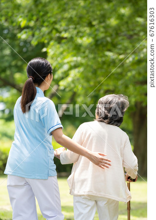 高級女子和照顧者在戶外康復後視圖 67616303
