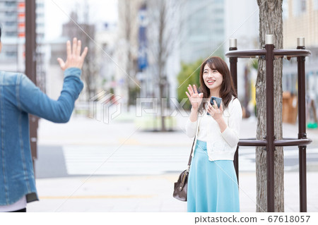A woman waving a hand 67618057
