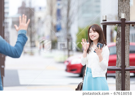 A woman waving a hand 67618058
