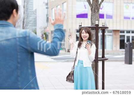 A woman waving a hand 67618059
