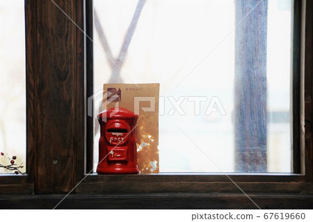 Piggy bank in a postbox placed on the windowsill 67619660