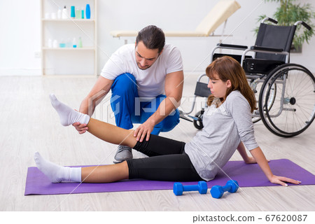 Leg injured woman doing sport exercises with personal coach Leg injured woman doing sport exercises with personal coach 67620087