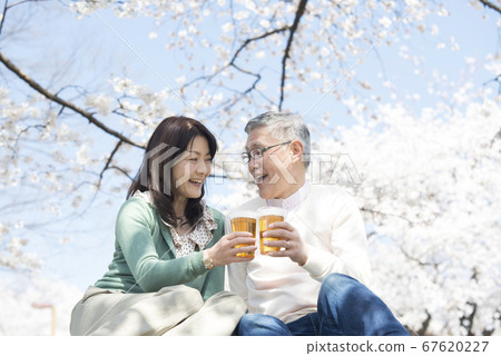 Middle couple drinking beer at Hanami Middle couple drinking beer at Hanami 67620227