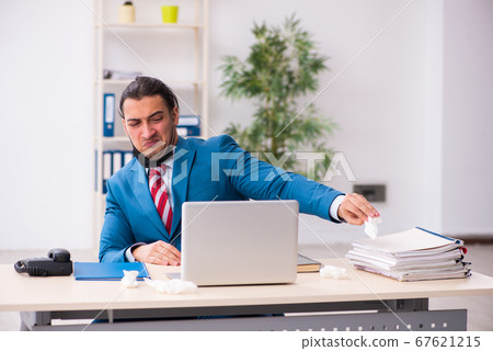 Sick male employee suffering at workplace from coronavirus 67621215