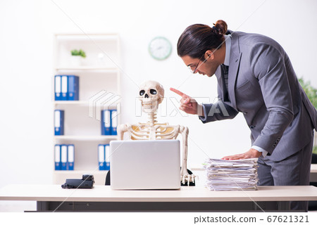 Young male employee and skeleton in the office Young male employee and skeleton in the office 67621321