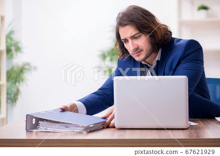 Young male employee unhappy with excessive work Young male employee unhappy with excessive work 67621929