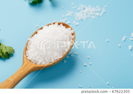 Sea salt in a wooden spoon on Large salt crystals 67622305