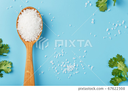 Sea salt in a wooden spoon on Large salt crystals 67622308